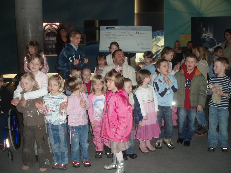 Overrækkelse af check i Planetariet med mange børn